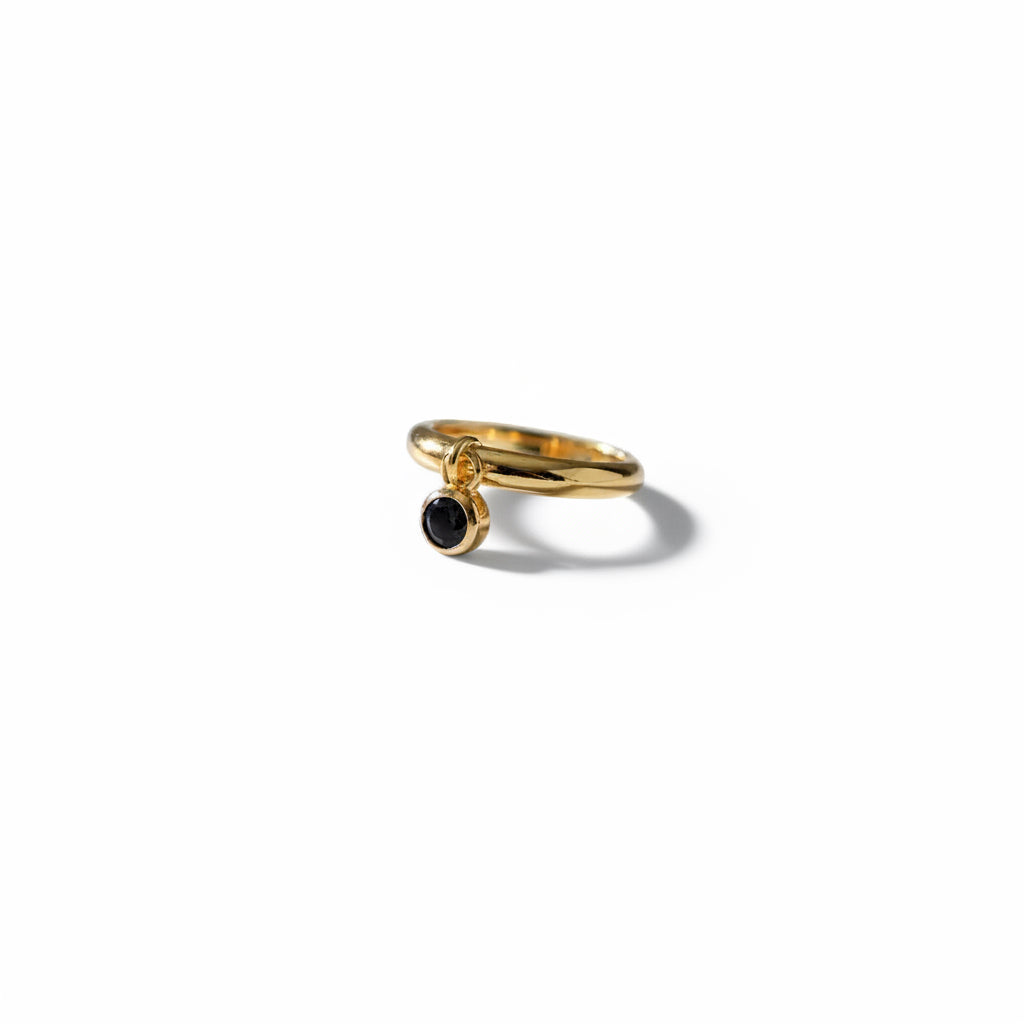 Gold ring with a black gemstone on a white background