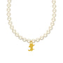 Pearl necklace with a gold bear pendant on a beige background