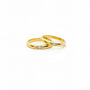  simple gold band ring with a round zirconia gemstone positioned in the center, displayed against a beige background.