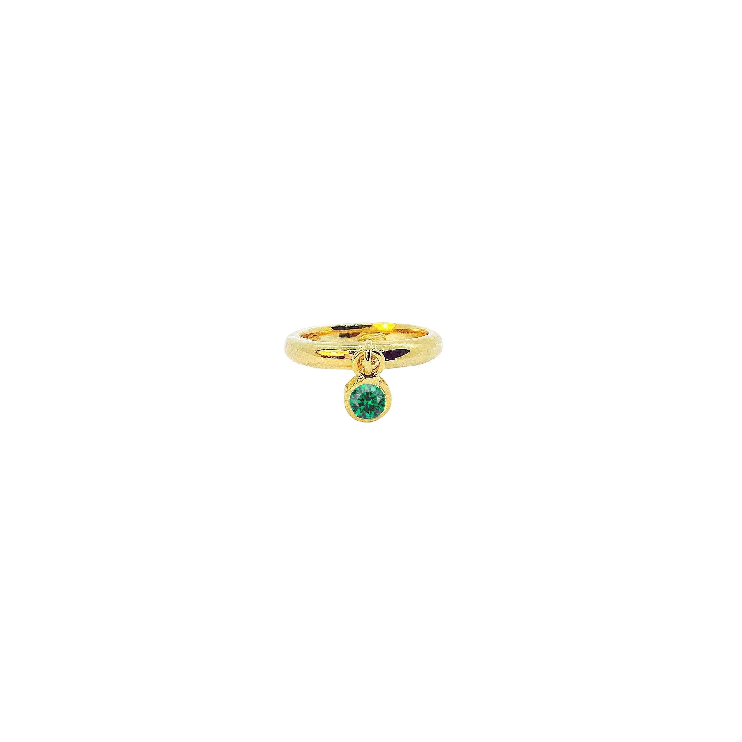 Gold ring with a green gemstone on a white background